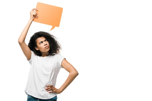 Mécontent afro-américain fille tenant bulle de discours orange et debout avec la main sur la hanche isolé sur blanc — Photo de stock