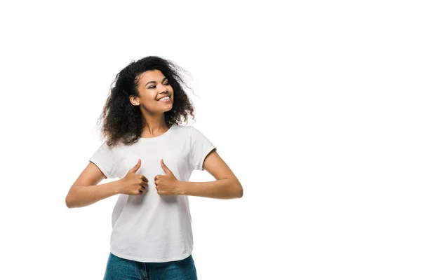 Mujer afroamericana rizada y positiva mostrando pulgares hacia arriba aislado en blanco - foto de stock