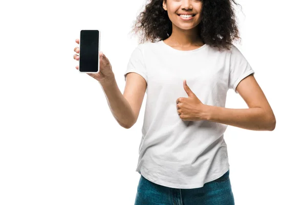 Vista cortada de menina americana feliz segurando smartphone com tela em branco e mostrando polegar isolado no branco — Fotografia de Stock