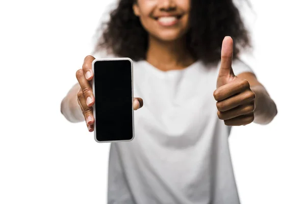 Ausgeschnittene Ansicht eines glücklichen afrikanisch-amerikanischen Mädchens, das Smartphone mit leerem Bildschirm hält und den Daumen vereinzelt auf weiß zeigt — Stockfoto