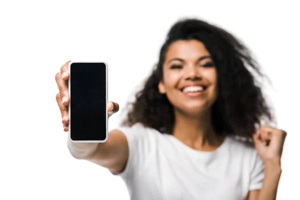 Selective focus of positive african american girl holding smartphone with blank screen and celebrating isolated on white — Stock Photo