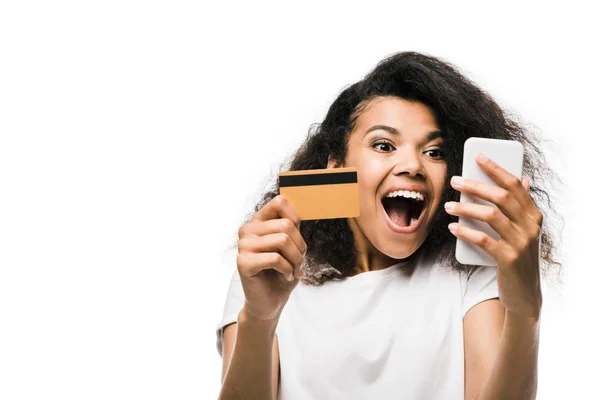 Збуджений афроамериканець Жінка тримає кредитну карту і дивлячись на смартфон ізольований на білому — стокове фото