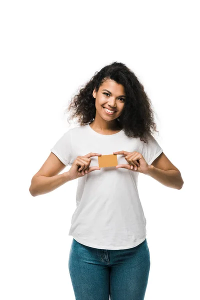 Alegre afroamericana mujer sosteniendo tarjeta de crédito aislado en blanco - foto de stock