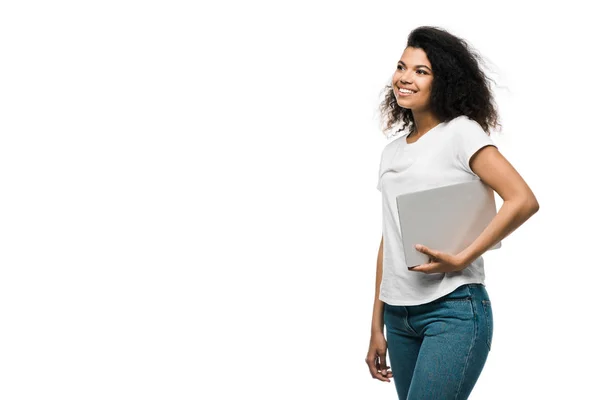 Alegre joven afroamericana mujer sosteniendo portátil aislado en blanco - foto de stock