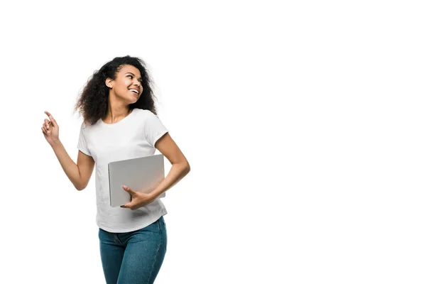Весела молода афроамериканка жестикулює, тримаючи ноутбук ізольовано на білому — стокове фото