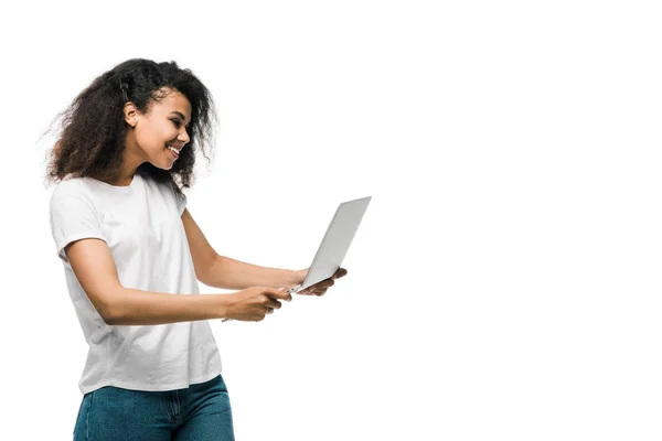 Happy young african american woman looking at laptop isolated on white — Stock Photo