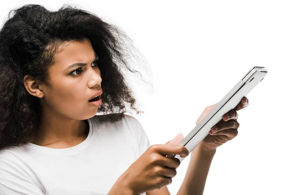 Surprised young african american woman looking at laptop isolated on white — Stock Photo