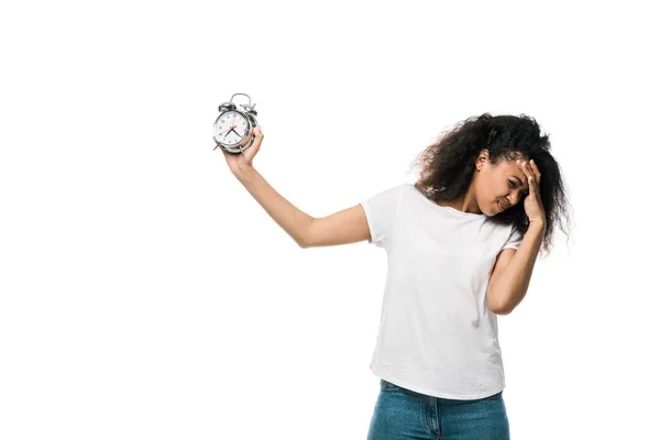 Tired curly african american girl holding vintage alarm clock isolated on white — Stock Photo