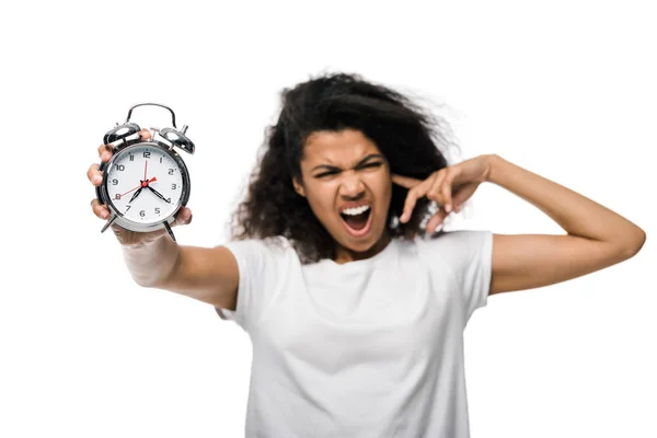 Selective focus of vintage alarm clock in hand of displeased curly african american girl isolated on white — Stock Photo