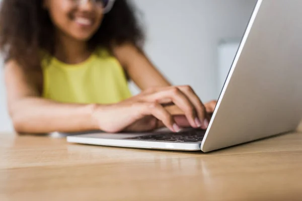 Selective focus of happy african american woman using laptop — Stock Photo