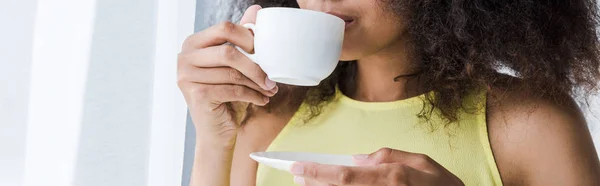 Panoramic shot of african american woman drinking coffee from cup — Stock Photo