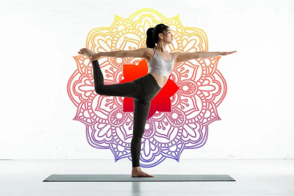 Asiatique femme pratiquant yoga sur tapis de yoga près de mandala ornement sur blanc — Photo de stock