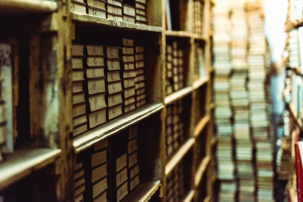 Selective focus of retro books on wooden shelves in library — Stock Photo