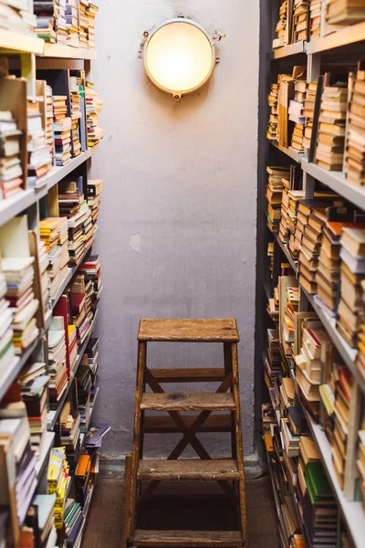 Vintage books on wooden shelves and ladder in library — Stock Photo