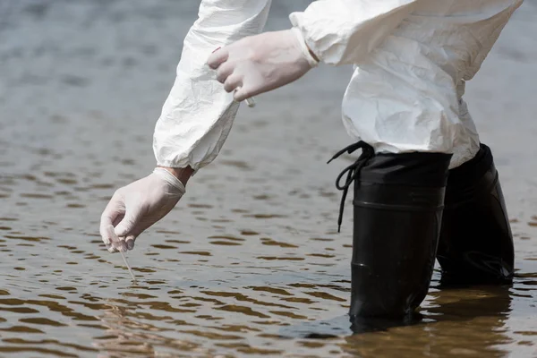 Vue partielle de l'inspecteur de l'eau dans des gants en latex avec éprouvette prélevant un échantillon d'eau — Photo de stock