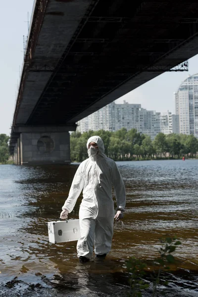 Water inspector in protective costume holding inspection kit in river — Stock Photo