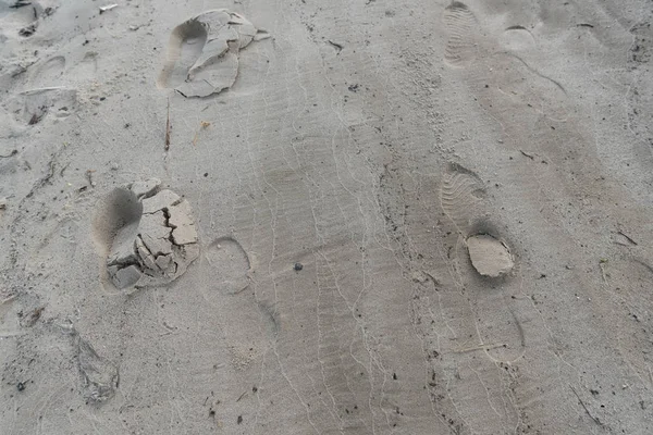 Draufsicht auf strukturierten braunen Sand mit menschlichen Fußabdrücken — Stockfoto