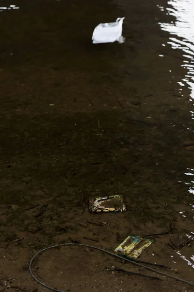 Plastikmüll auf sandigem Grund im Fluss — Stockfoto