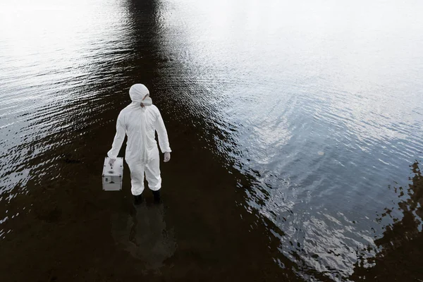 Vista aérea del inspector de agua en traje de protección que sostiene el kit de inspección en el río - foto de stock