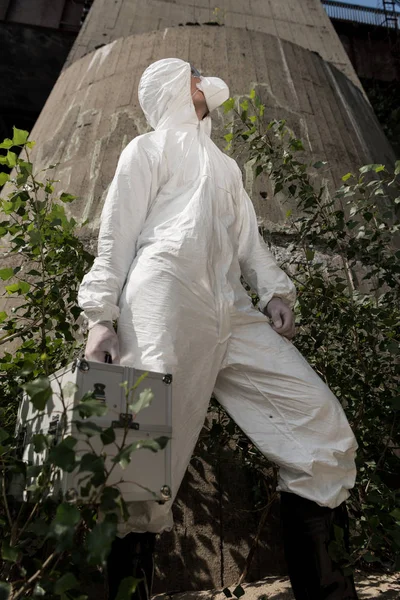 Low angle view of ecologist with inspection kit standing near plants — Stock Photo