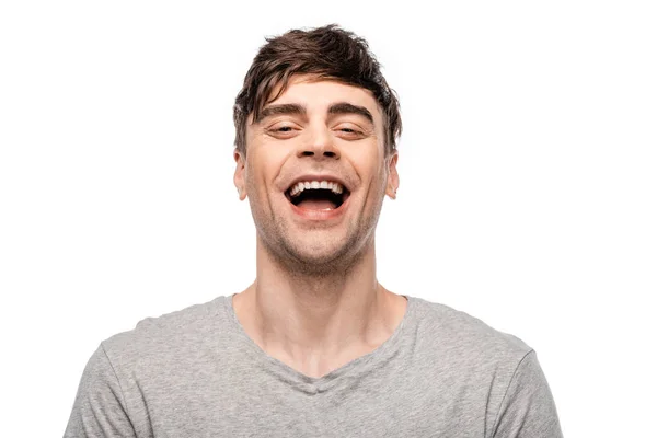 Cheerful young man laughing while looking at camera isolated on white — Stock Photo