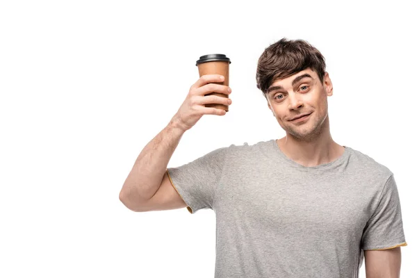 Веселый молодой человек с одноразовой чашкой и улыбаясь в камеру изолированы на белом — стоковое фото