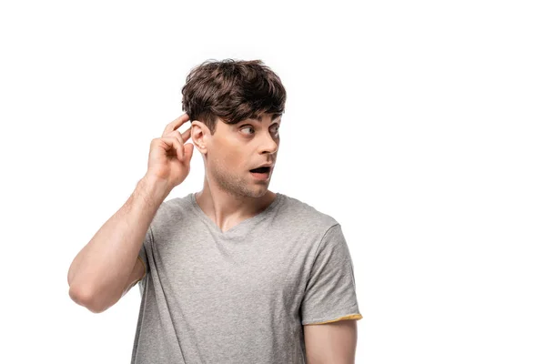 Discouraged young man looking away and touching head with hand isolated on white — Stock Photo