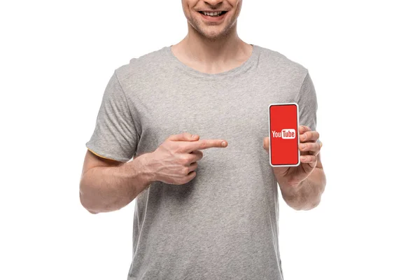 KYIV, UKRAINE - MAY 16, 2019: cropped view of smiling man pointing at smartphone with youtube app, isolated on white — Stock Photo