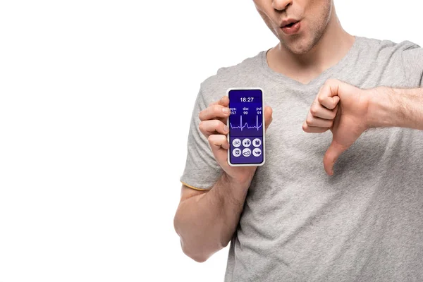 Vista ritagliata di uomo mostrando pollice verso il basso e smartphone con app salute, isolato su bianco — Foto stock