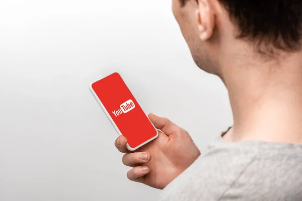 KYIV, UKRAINE - MAY 16, 2019: cropped view of man using smartphone with youtube app, isolated on grey — Stock Photo