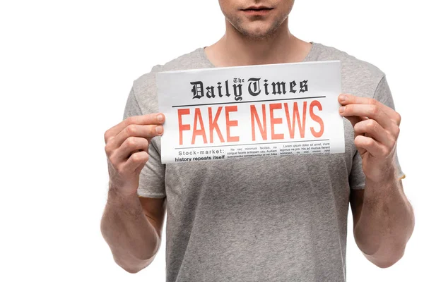 Vista ritagliata di giovane uomo che mostra giornale con notizie false isolate su bianco — Foto stock