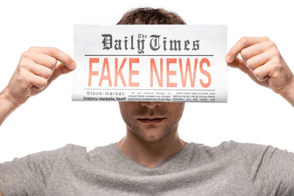 Young man showing newspaper with fake news isolated on white — Stock Photo