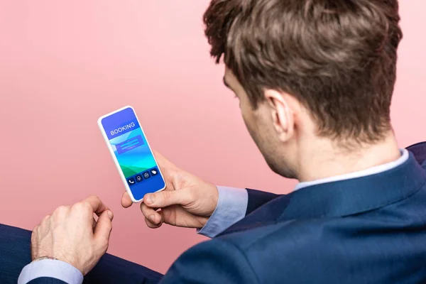 Cropped view of businessman using smartphone with booking app, isolated on pink — Stock Photo