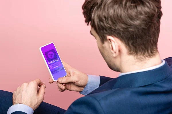 Cropped view of businessman using smartphone with shopping app, isolated on pink — Stock Photo