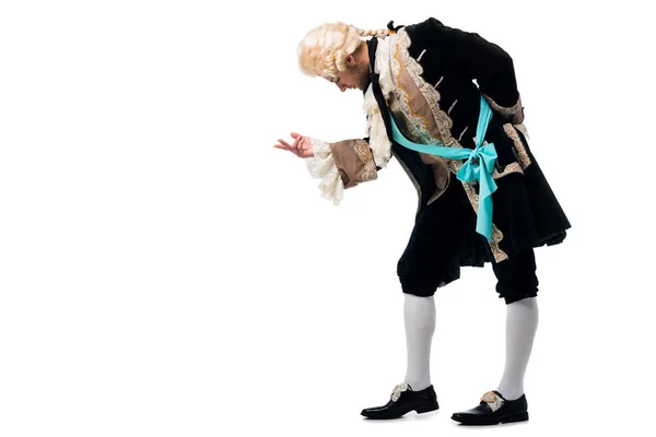 Handsome victorian gentleman in wig gesturing while bowing down isolated on white — Stock Photo