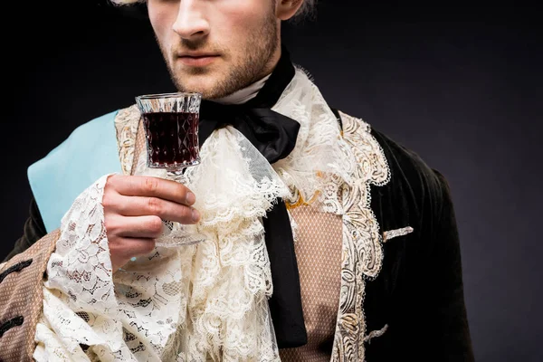 Обрізаний вид вікторіанського чоловіка, що тримає келих для вина на чорному — стокове фото