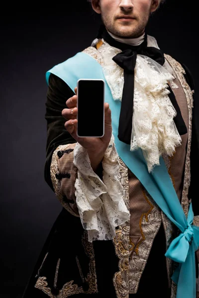 Vista cortada do homem vitoriano segurando smartphone com tela em branco no preto — Fotografia de Stock