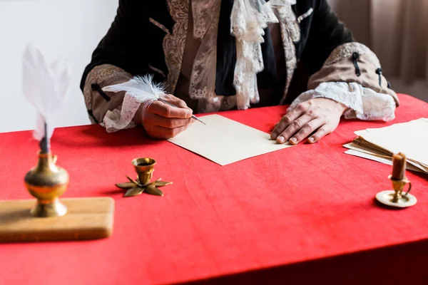 Обрізаний вид на вікторіанського чоловіка, що тримає перо біля паперу — стокове фото
