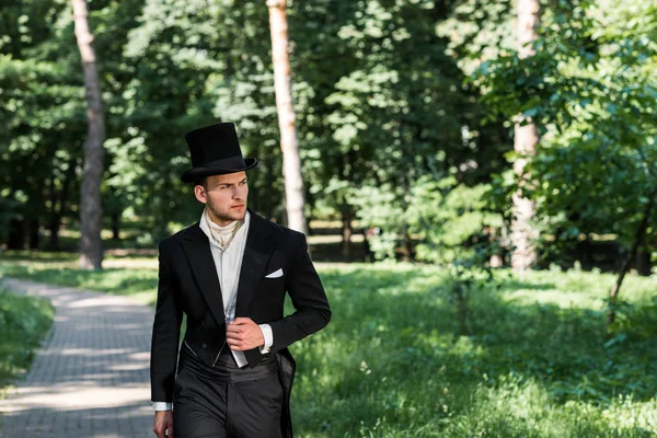 Schöner junger viktorianischer Mann mit Hut steht draußen — Stockfoto
