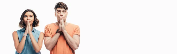 Panoramic shot of hoping man and woman looking up and showing pray gestures isolated on white — Stock Photo