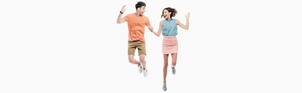 Panoramic shot of happy man and woman looking at each other and jumping isolated on white — Stock Photo