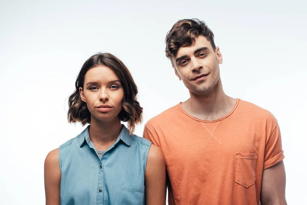 Homme souriant et femme sérieuse regardant la caméra sur fond blanc — Photo de stock