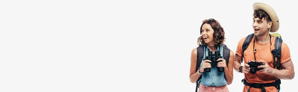 Panoramic shot of two young tourists smiling while looking away isolated on grey background — Stock Photo