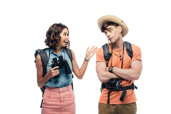 Mujer alegre sosteniendo binocular mientras habla con hombre reflexivo aislado en blanco - foto de stock