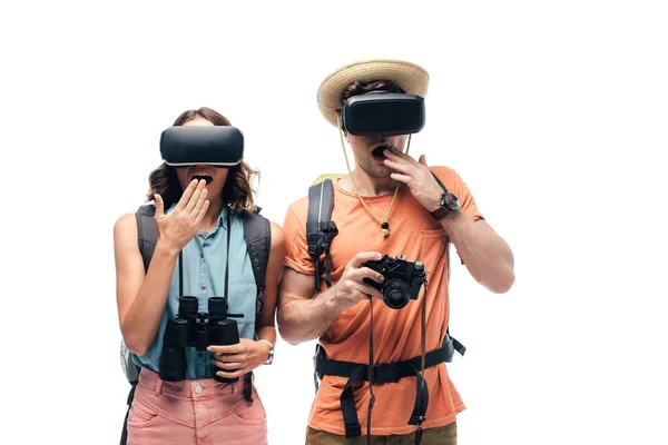 Dos jóvenes sorprendidos turistas utilizando auriculares de realidad virtual aislados en blanco - foto de stock