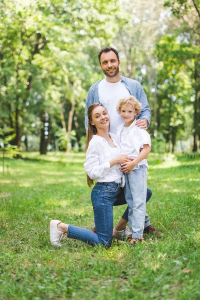 Glückliche Familie blickt in die Kamera und posiert im Park — Stockfoto
