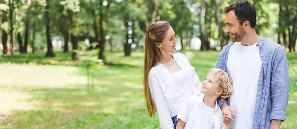 Colpo panoramico di famiglia in abiti casual in posa nel parco — Foto stock