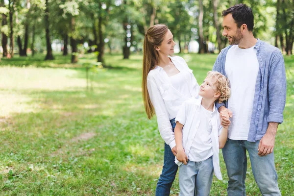 Family in casual clothes posing in park with copy space — Stock Photo