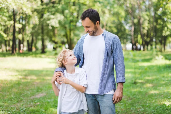 Handsome father hugging adorable son in park — Stock Photo