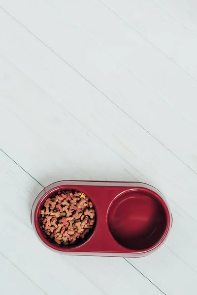 Top view of bowl with dog food on white wooden surface — Stock Photo